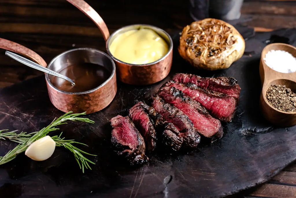 Dry-aged grass-fed steak seared and sliced on a board